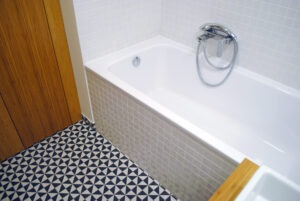 Koupelna s retro černobílou dlažbou a bílými obkladz