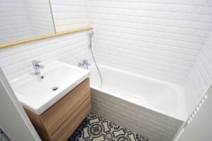 Malá koupelna s černobílou dlažbou a bílými obklady