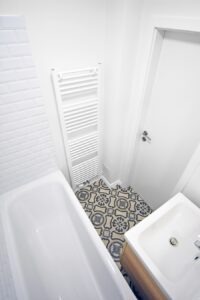 Malá koupelna s černobílou dlažbou a bílými obklady