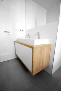 Koupelna s šedou dlažbou a dřevěnými doplňky